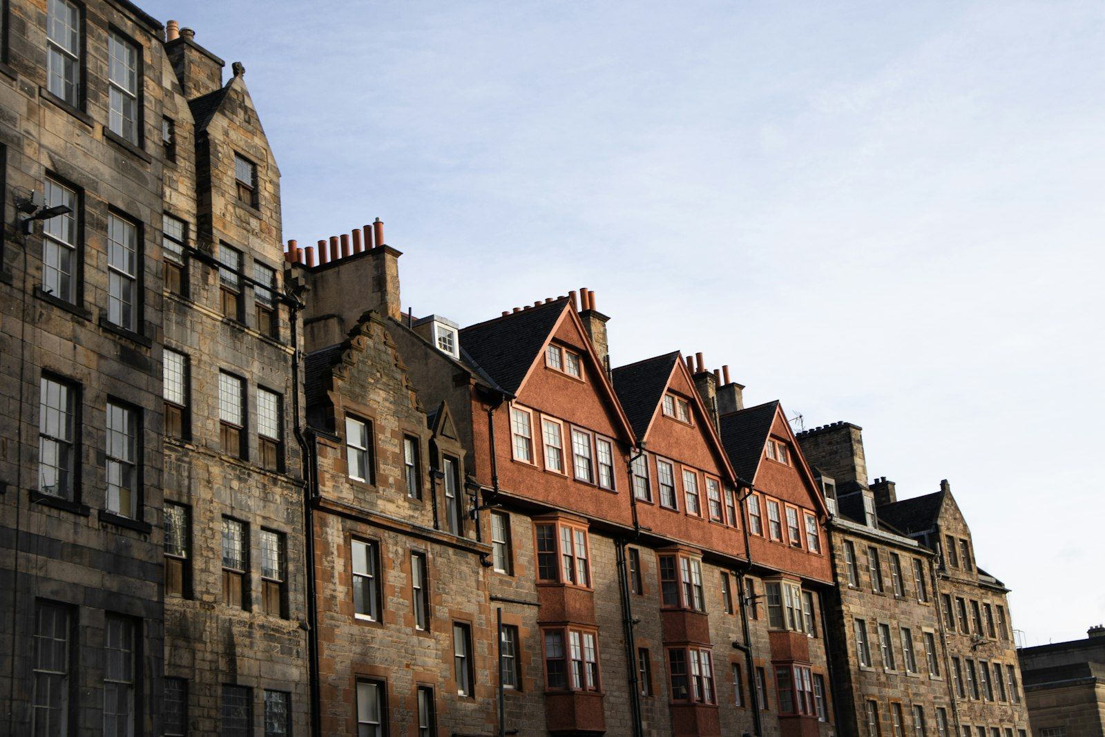 Tall Victorian red-brick houses with ornate gables along a city street